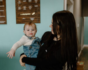 Haley McCaskill, COO of Revive Infusions & Wellness in Roseburg, Oregon, holding her toddler daughter, supporting patients with weight loss, nutrition coaching, and wellness programs in Douglas County.