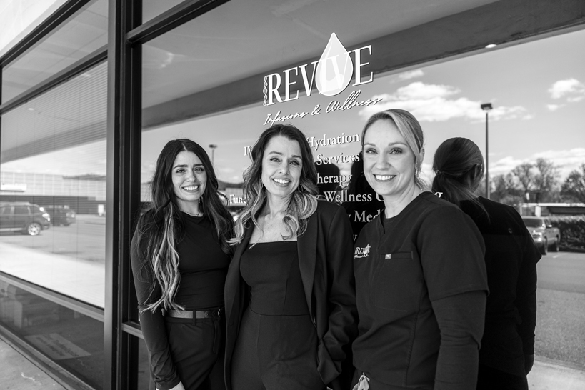 our-team-Revive-Infusions-&-Wellness-douglas-county-oregon Black-and-white photo of the medical team at Revive Infusions & Wellness in Roseburg, Oregon, standing in front of the clinic, offering root-cause treatments, IV therapy, peptide protocols, hormone optimization, and wellness programs for men and women.