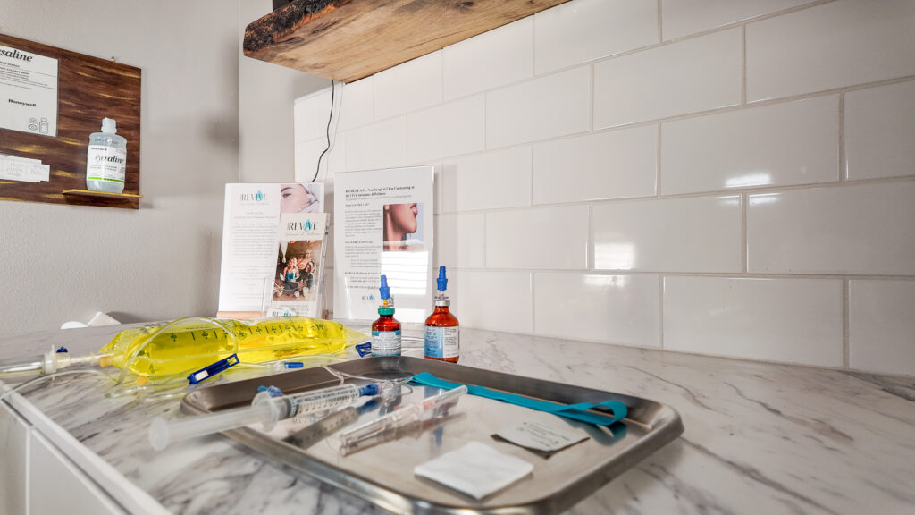 Granite countertop in a medical exam room with white subway tile and medical tray holding peptide injections and IV bag at Revive Infusions & Wellness, a luxury medical spa in Roseburg, Oregon, offering weight loss and hormone optimization therapies.