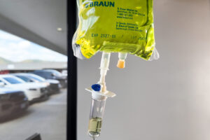 Bag of IV nutrients with glutathione connected to an IV drip in a treatment room at Revive Infusions & Wellness for antiaging, biohacking, and hydration in a luxury medical spa in Roseburg, Oregon.