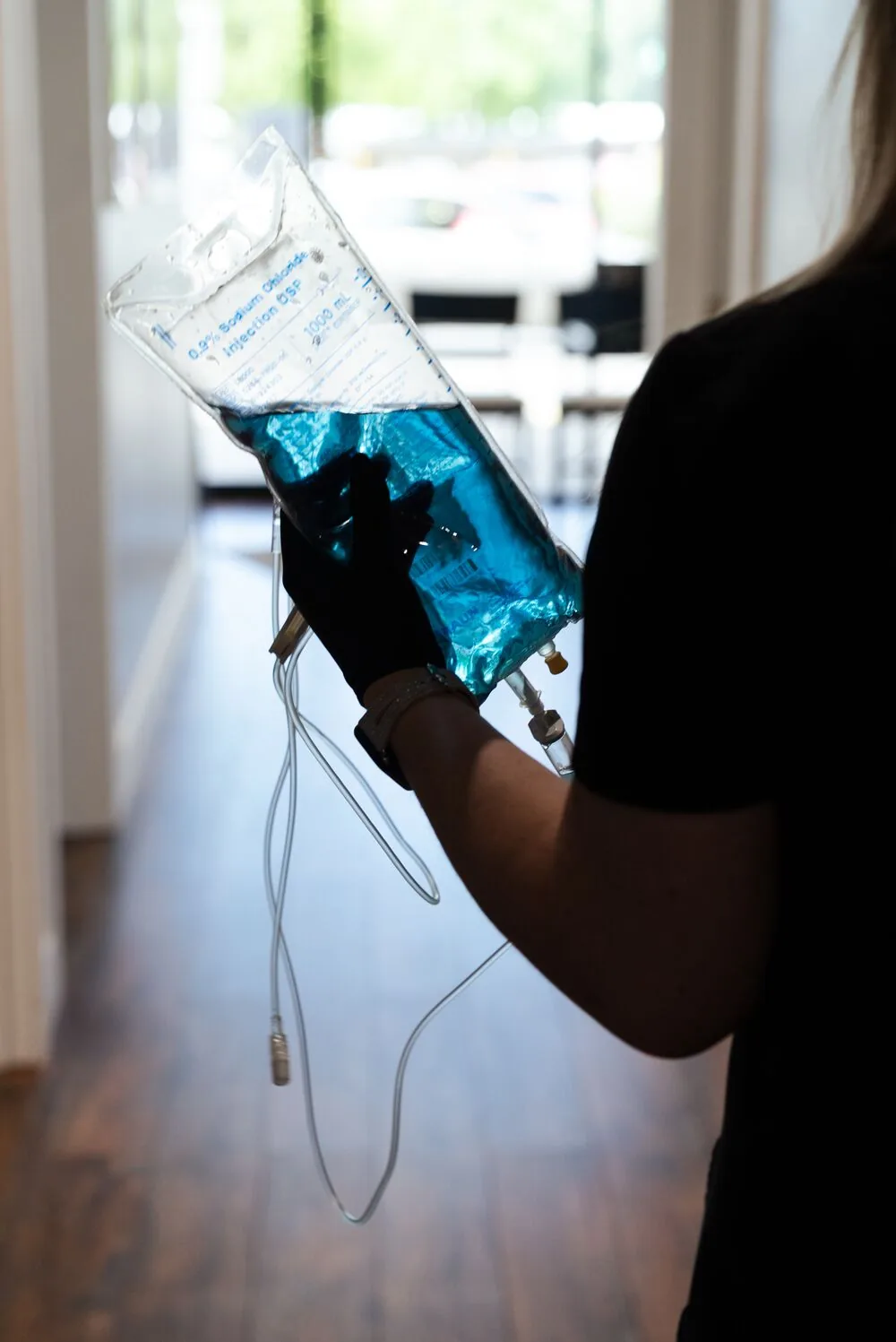 REVIVE clinician preparing an IV nutrient bag in the Wellness Lounge